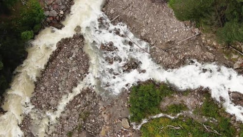 Narrow River with Fast Water Streams Runs Down Among Rocks