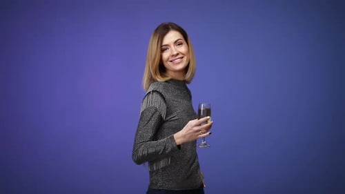 Woman Toasts With Champagne Against Blue Background
