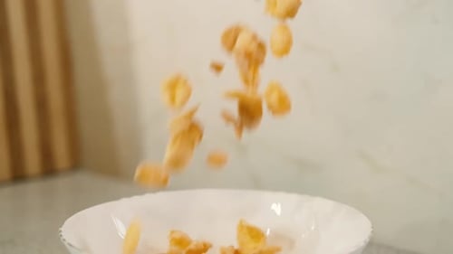 Cereal Flakes Pouring into a White Bowl