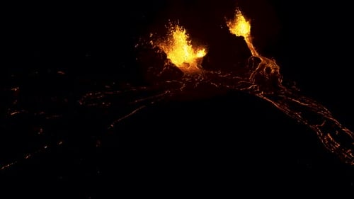 Aerial flying back from an active erupting volcano at night.