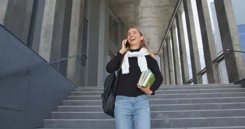 Girl in Casual Clothes Going Down the Stairs with Her Textbooks from University building