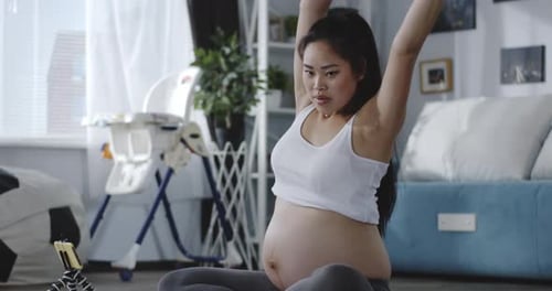 Pregnant Woman Exercising with Exercise Ball at Home