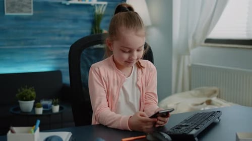Young Girl Using Smartphone at Her Desk