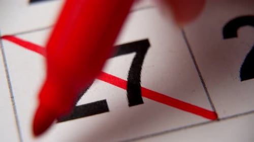 27-е число календаря перечеркнуто красным крестом в макросе на белом листе