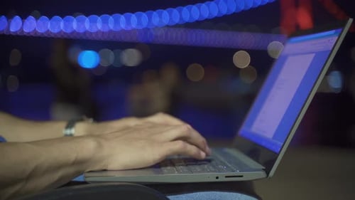 Hand and keyboard image of working on laptop. Night.