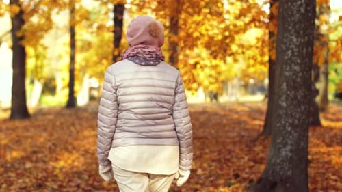 Happy Senior Woman Walking Along Autumn Park 6