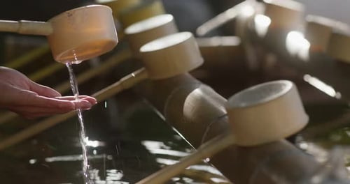 Woman wash hand before enter the japanese temple