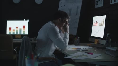 Müder Geschäftsmann berührt bei der Analyse von Daten und Finanzdiagrammen den Kopf