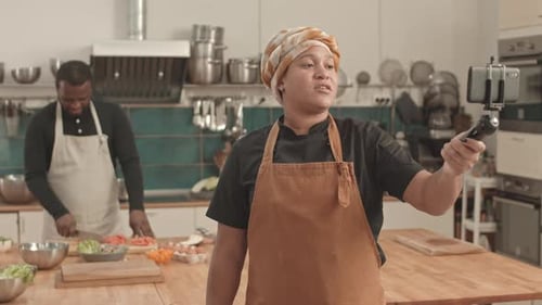 Une femme chef fait des vlogs sur son lieu