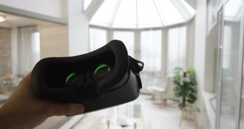 Virtual Reality Headset Held in a Modern Home