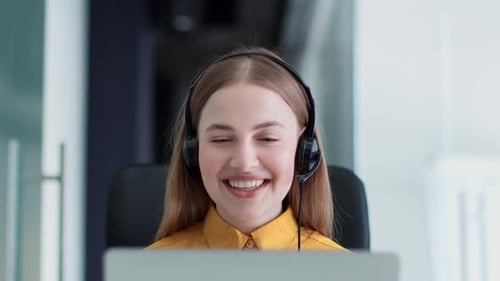 Young Woman in Headset Works in Office