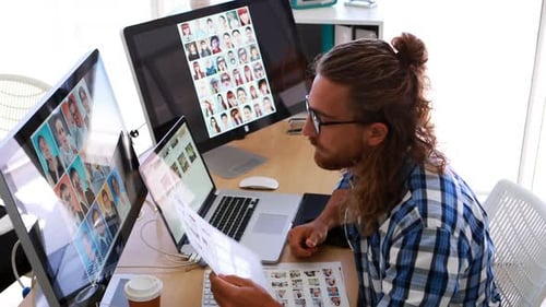 Designer Working at Desk with Multiple Monitors