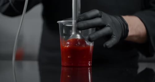 Chef Mixing Red Sauce in Cup