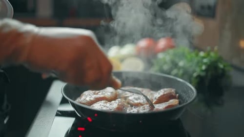 Chef Cooking Meat Steaks in Pan On Stove