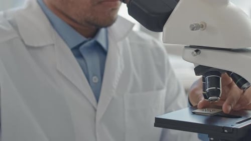 Cientista de laboratório olhando para chip de computador sob microscópio