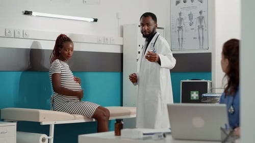 Pregnant Woman Talking to Doctor in Medical Office