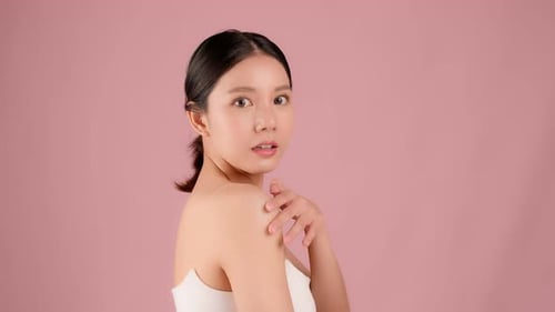 Slow motion Beauty shot of Beautiful Asian girl looking at camera isolated on pink background