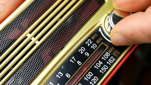 Human Hands with Fingers Adjusts the Tuning Old Radio To Radio Wave.