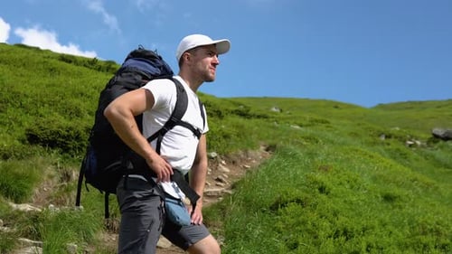 Man Hiking with Backpack in Green Mountains