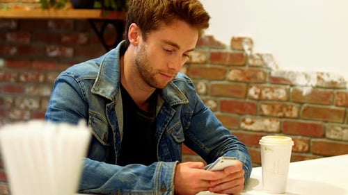 Mann benutzt Handy am Tisch