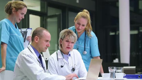 Medical Professionals Collaborating on Laptop in Hospital