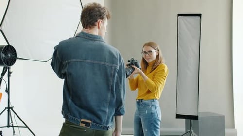 Slow Motion of Photographer Taking Pictures of Male Model Using Camera in Studio