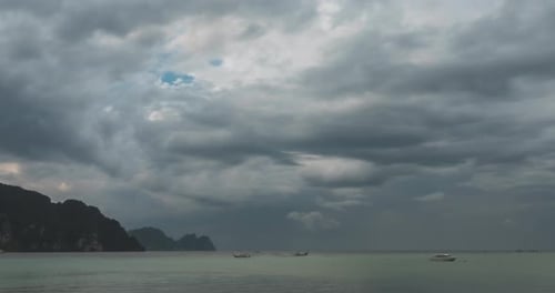 Zeitraffer der Regenwolken über Strand- und Meereslandschaft mit Booten. Tropischer Sturm im Meer.