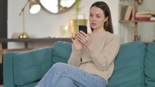 Woman Using Smartphone While Relaxing on Couch