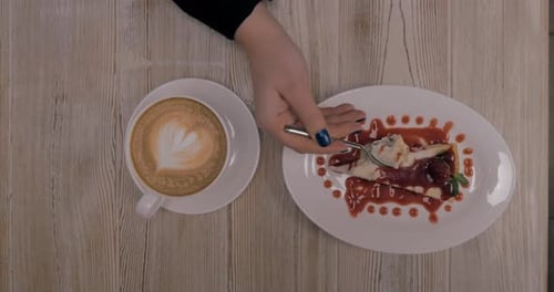 Woman having dessert with coffee in restaurant