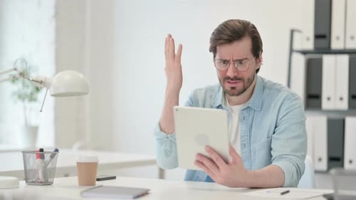 Man Using Tablet Device Gets Frustrated At Work