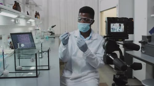 Scientist with Syringe Records Video in Bright Lab