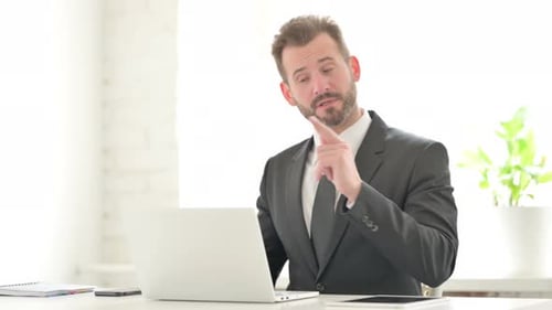 Young Businessman Talking on Video Call on Laptop in Office