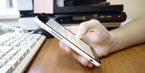 Hand Using Smartphone on Desk at Work
