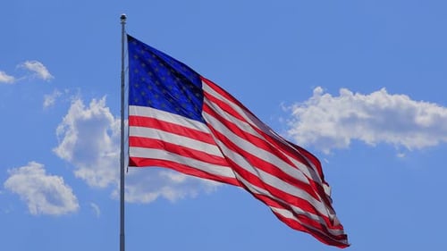 Waving American Flag Against Blue Sky