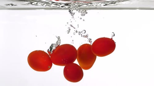 Tomatoes Falling into Water with Bubbles