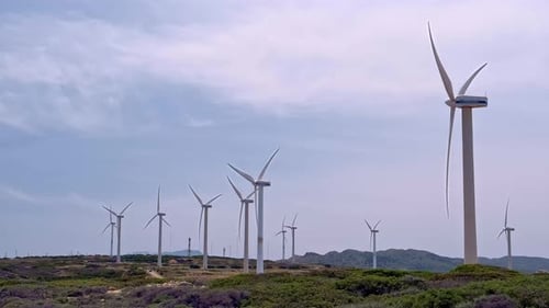 Diagonal Shot of Wind Turbine Farm in Hill Landscape on Sunny Day