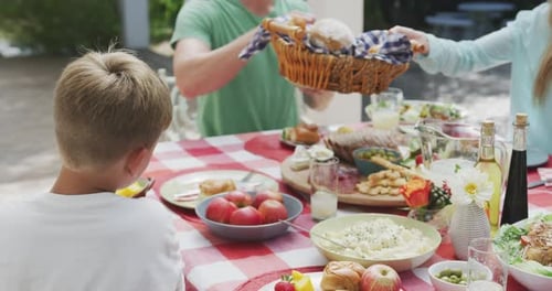 Family Enjoys Picnic With Food Outdoors in Summer