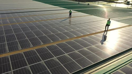 4K Professional engineer using tablet maintaining solar cell panels together on building rooftop.