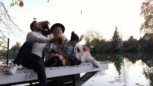 Happy Big Family with Their Dog on a Walk at Sunset Near the Lake on an Autumn Day