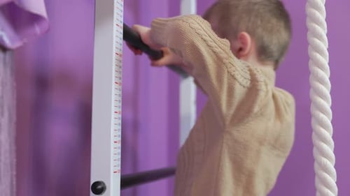 Boy Climbing Wall Bar Ladder in Home Gym