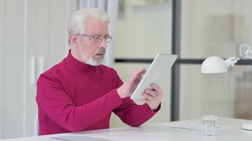 Senior Man Using Tablet at Desk