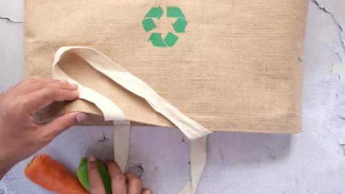 Cartel de flechas recicladas en una bolsa de compras con verduras