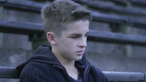 Mec frustré assis sur le banc regardant ses camarades de classe s'entraîner, disqualification