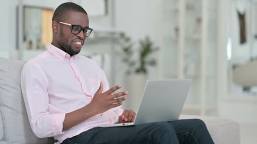 Man Laughing During Video Chat at Home