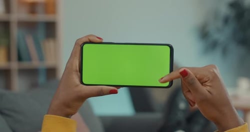 Woman Holding Smartphone and Scrolling on Green Screen