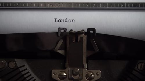 Typing city name London on a vintage typewriter. Close up.