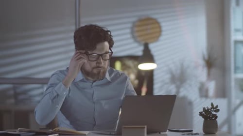 Frustrated Man Working in Office Overtime