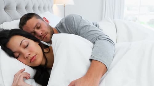 Couple sleeping peacefully on bed