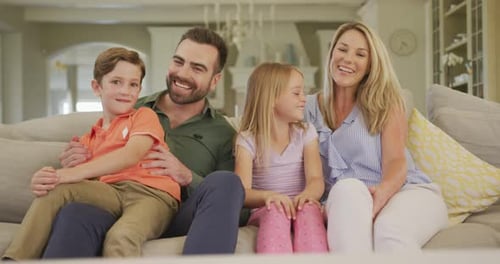 Cheerful Family Smiling Together on Couch at Home
