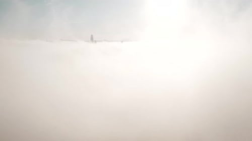 Aerial View of City Skyline Emerging from Clouds